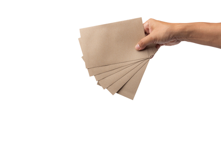Man hand sends a brown envelope isolated on white background with clipping path, It represents the symbol of human communication before being replaced by a smartphone.の写真素材