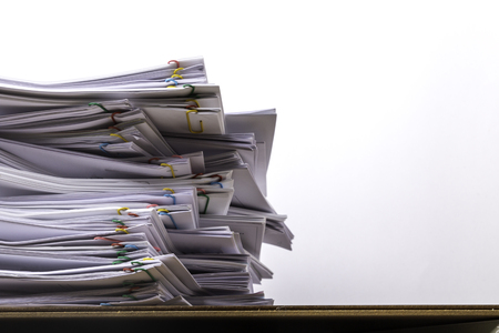 Stack of document paper with colorful paperclip place on wooden table on white background, business concept paperless used and work overload .の写真素材
