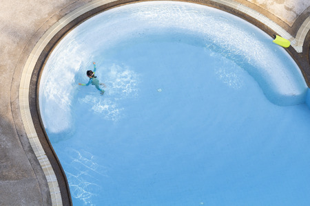 Top view of Minimalist Asian little girl practicing swimming in the pool.の写真素材