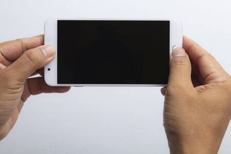 Man hand holding horizontal smartphone with black screen. Comunication concept.の写真素材