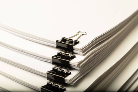 Stack of document paper with colorful paperclip place on wooden table, business concept paperless used and work overload.の写真素材