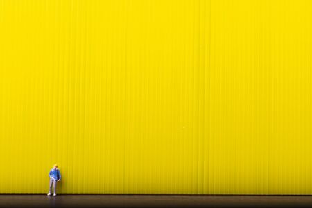 Miniature traveler people standing on yellow background with copy space, Concept of minimal.の写真素材