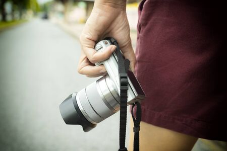 Female tourists holding digital cameras, walking street photography.の写真素材