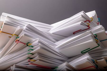 Stack of overload document paper with colorful paperclip place on black, business concept footage paperless used.の写真素材