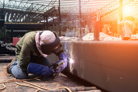 Male worker wearing protective clothing repair grinding bottom plate storage tank industrial...