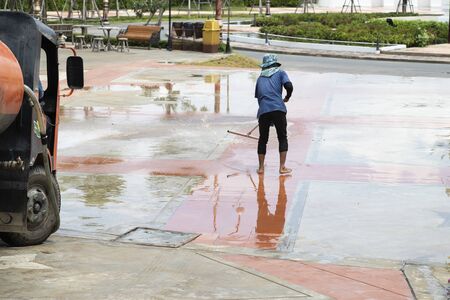 The worker is cleaning the floor alone outdoors.の写真素材