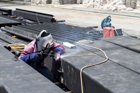 Male worker wearing protective clothing repair grinding bottom plate storage tank industrial construction. concept for safety first.の写真素材