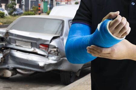 Close up man holding hand with blue bandage as arm injury concept with car accident.の写真素材