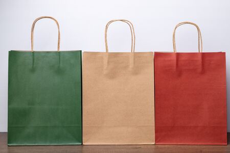 Green brown and red paper bags on white background.の写真素材