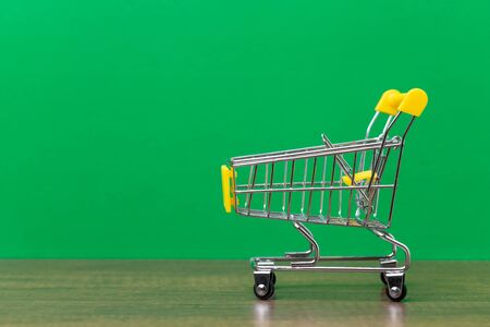 Yellow cart model on green background, Shopping symbols in shopping malls and general business concept.の写真素材