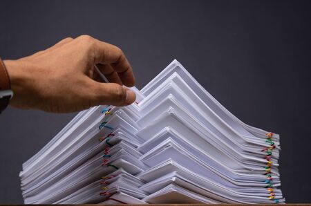 Hand pick up Stack overload document report paper with colorful paperclip place and copy space, business concept footage paperless usedの写真素材
