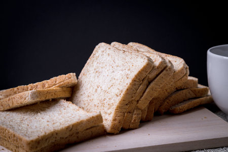 Close-up Homemade slide bread with hot coffee cup and newspaper on the wooden with copy space on...
