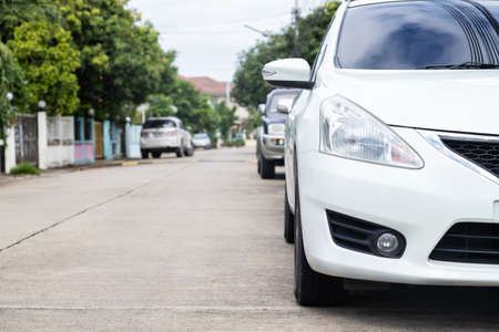 White car parked in a row on the road, outdoor parking with copy space.の写真素材