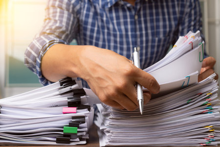 Business man hand pick up Stack overload document report paper with colorful paperclip, business and...