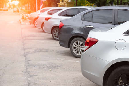 Silver car parking in line and car running background.の写真素材