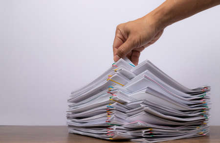 man hand pick up Stack overload document report paper, concept of paperless.の写真素材