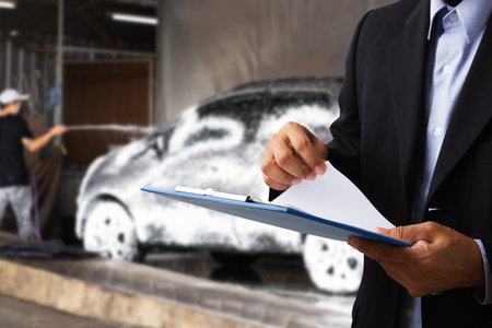 The shopkeeper is checking the number of cars washed in the shop.の写真素材
