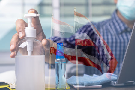 Bouble exposure of Alcohol gel to prevent corona virus covid-19 infection with male employee working in back. Thailand preventtion covid-19 concept.の写真素材