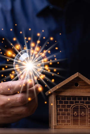 Vertical hand man holding illuminated light bulb, concept creativity with bulbs shine glitter, ideas for sustainable business development innovation and inspiration concept.の写真素材