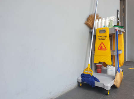 The warning signs cleaning in process the floor of the building and janitorial car parked in back to remind people to walk safely.の写真素材