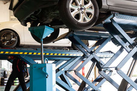 The car with mechanic oil change in the car service shop.の写真素材