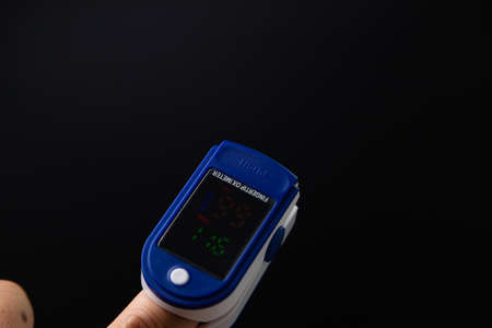 Pulse oximeter used to measure pulse rate and oxygen levels of 2019 test on black background.の写真素材