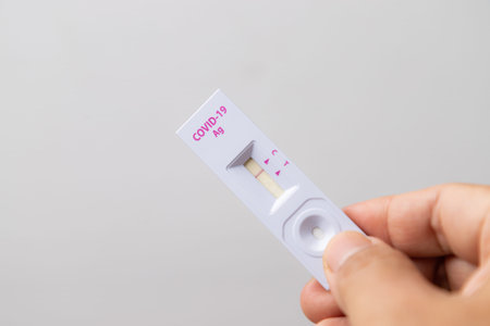 Hand holding Rapid kits of  Ag test or ATK seen on white background with copy space, concept for...