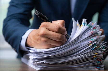 Businessman signing document after reading the agreement in office, hand writing.の写真素材