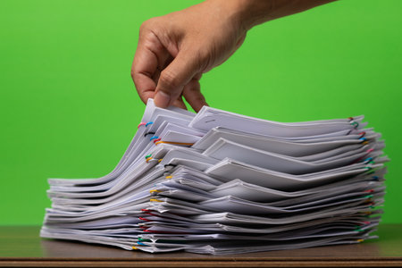 Close-up of hand pick up Stack of Group report papers Document clipped in color clips, business, and education concept.の写真素材