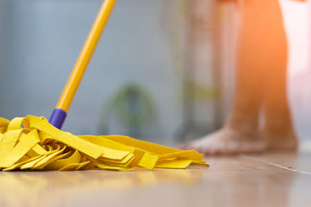 Close-up of cleaning wooden floor with yellow wet mopの写真素材