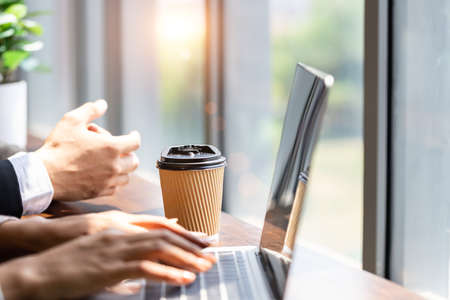 Paper coffee mugs for hot coffee on the table for business people or employees who want to negotiate business or work anywhere, the concept of co-working spaceの写真素材