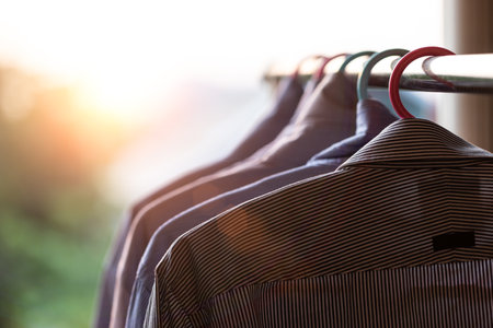 The men's shirts hung on the clothesline as the fair light shone through.の写真素材