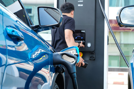 Owner Electric car charging at EV station, concept of green energy and eco power produced from sustainable source to supply to charger station in order to reduce CO2 emission.の写真素材