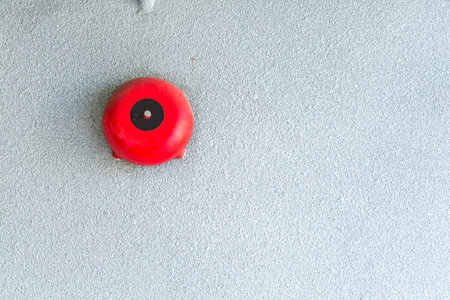 Red fire alarm mounted on the crack wallの写真素材