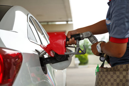 Closeup of woman pumping gasoline fuel in car at gas station. Petrol or gasoline being pumped into a...