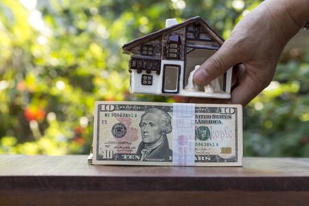 house model with dollar cash stack in jar glass or bottle glass closeup and on backgroundの写真素材