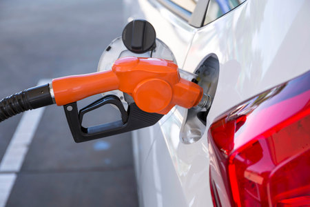 transportation and ownership concept - man pumping gasoline fuel in car at gas station