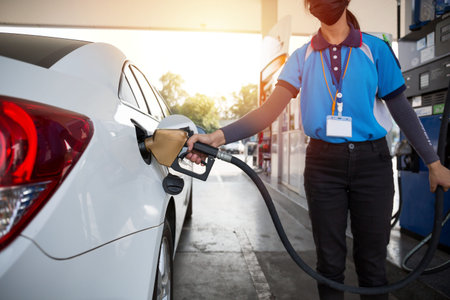 Transportation and ownership concept - woman pumping gasoline fuel in car at gas station