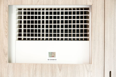 close up big white standing air conditioner next to wood wall indoor hotel.の写真素材
