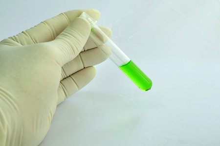 A medical technician holding a tube of green solutionの写真素材