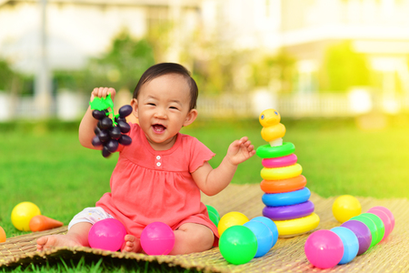 Cute Asian baby playing with toys in playgroundの写真素材