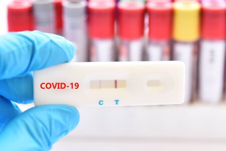 Positive test result by using rapid test device for COVID-19 virusの写真素材