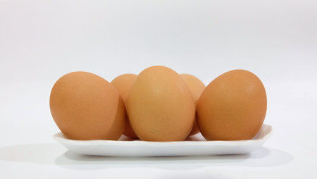 Five eggs in a plate on white background.