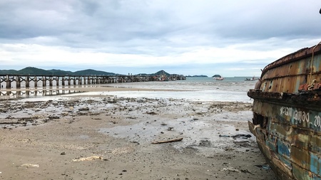 Bridges that extend into the sea, and old ships under the wide sky, background.の素材