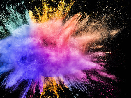 Explosion of colored powder, isolated on black background. Abstract colored background