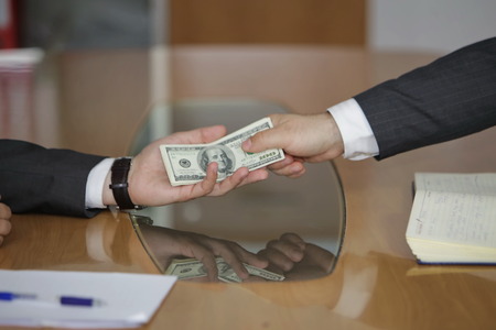 Corruption. Businessman in a suit takes a bribeの写真素材