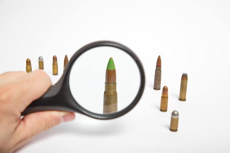 Magnifying glass and AK47 bullet close upの写真素材