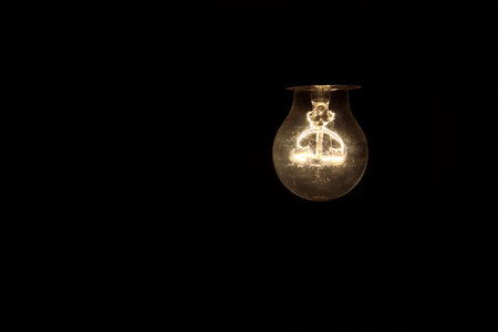 Old light bulb glowing in dark