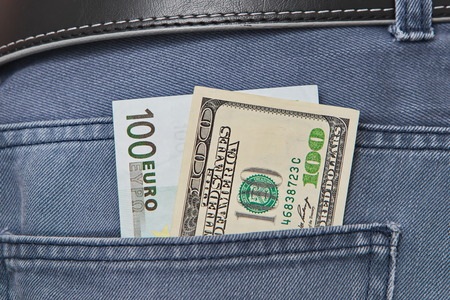 American dollar and Euros bills in jeans pocket backgroundの写真素材