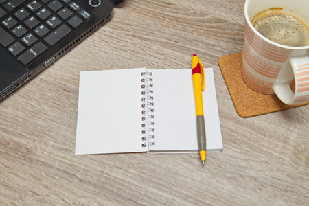 Desktop from above. Office space with an empty note book at coffee time looking for inspirational...